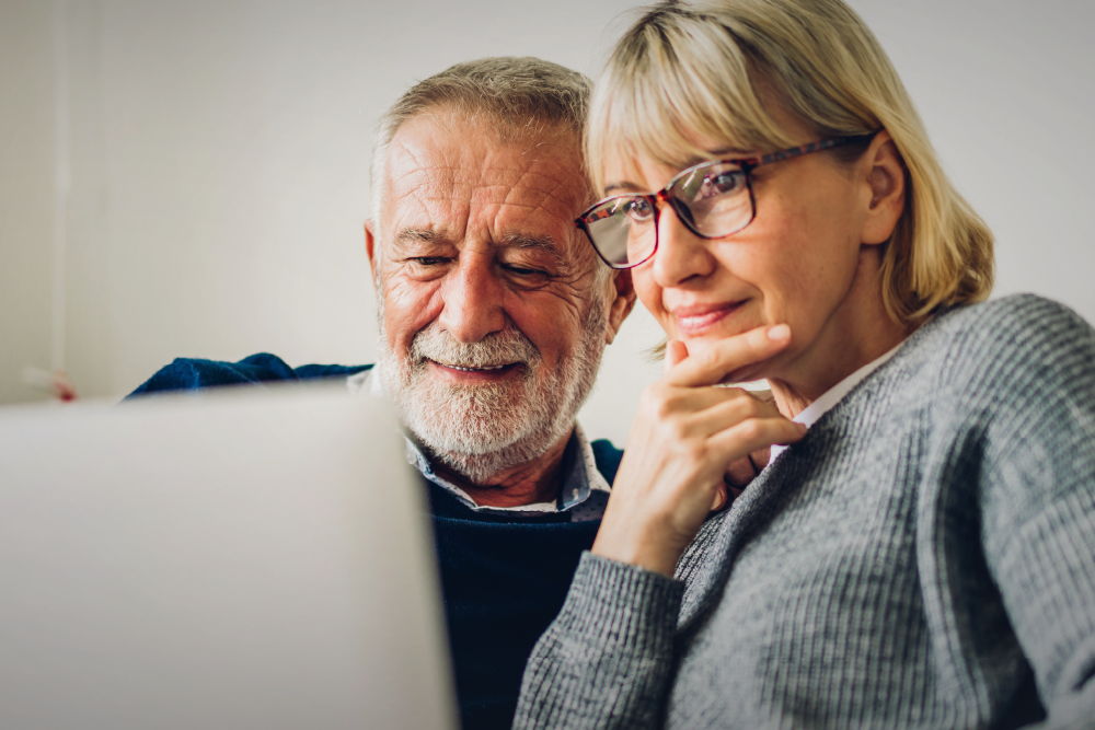 A couple views a website looking for helpful information. Text over the image says, “Is Your Urology Practice Website Driving Conversions—or Costing You Patients?”